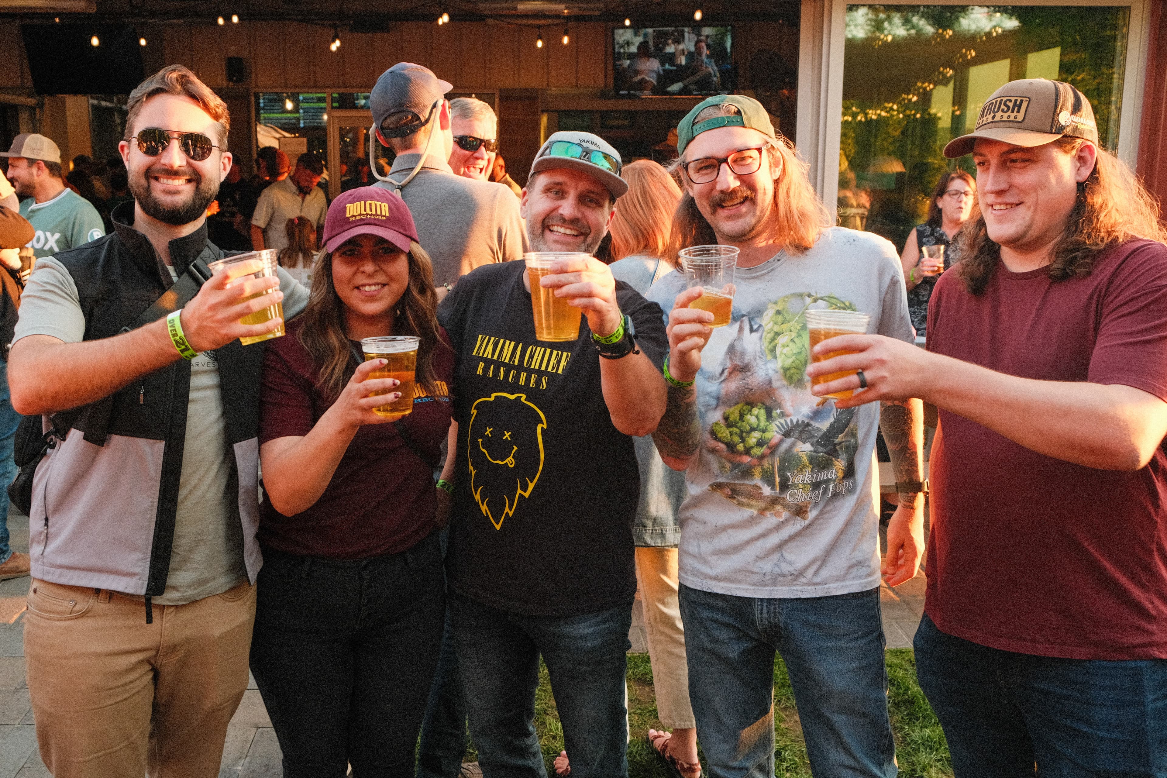 outdoor celebration with group showing the camera their beers